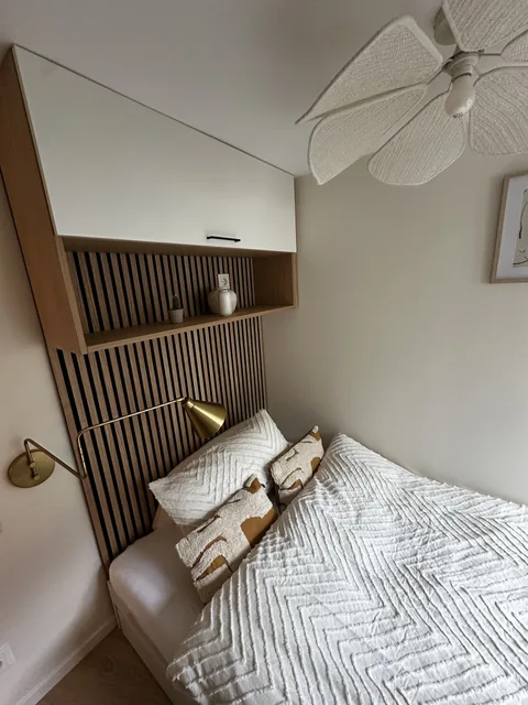 Wandschrank und Holzlamellen über dem Bett